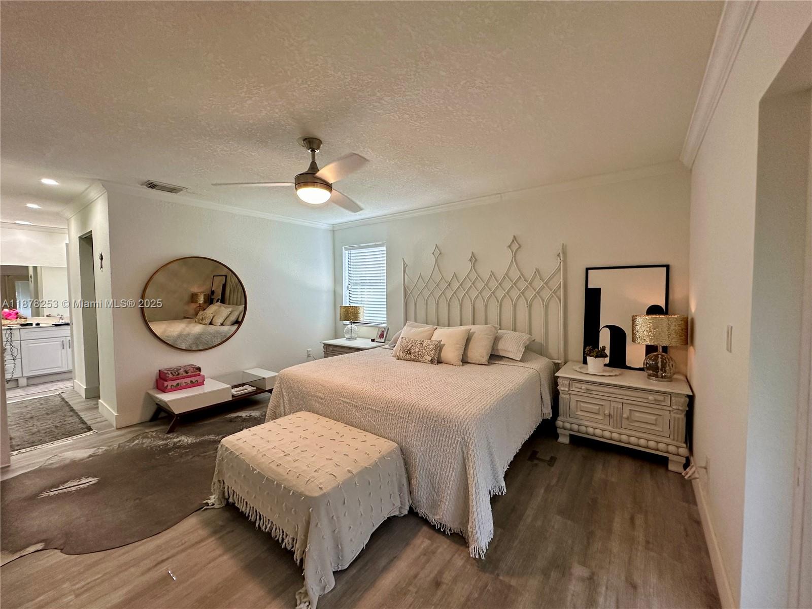 23304 Southwest 58th Avenue, Unit B Boca Raton, FL 33428 - Photo 11 of 32 a bedroom with a bed and a chandelier