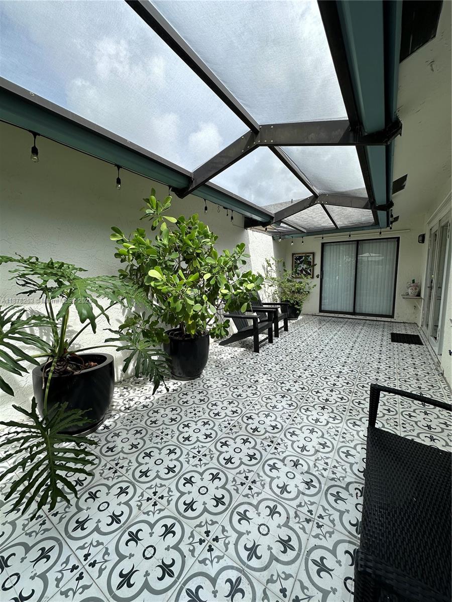 23304 Southwest 58th Avenue, Unit B Boca Raton, FL 33428 - Photo 23 of 32 a bunch of flowers in a patio
