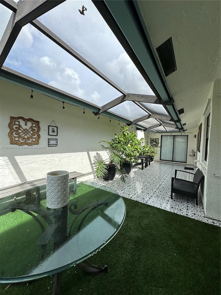 23304 Southwest 58th Avenue, Unit B Boca Raton, FL 33428 - Photo 26 of 32 a backyard of a house with table and chairs