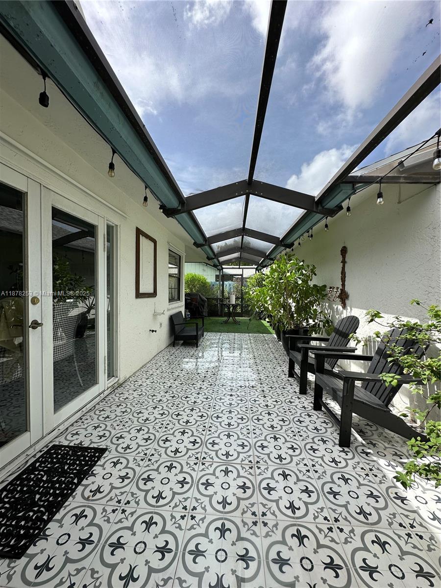 23304 Southwest 58th Avenue, Unit B Boca Raton, FL 33428 - Photo 27 of 32 a view of a patio with table and chairs under an umbrella