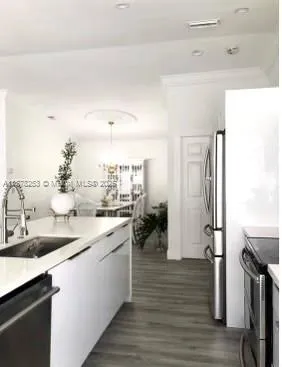 a kitchen with a sink refrigerator and cabinets