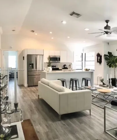 a living room with stainless steel appliances kitchen island granite countertop furniture and a view of kitchen