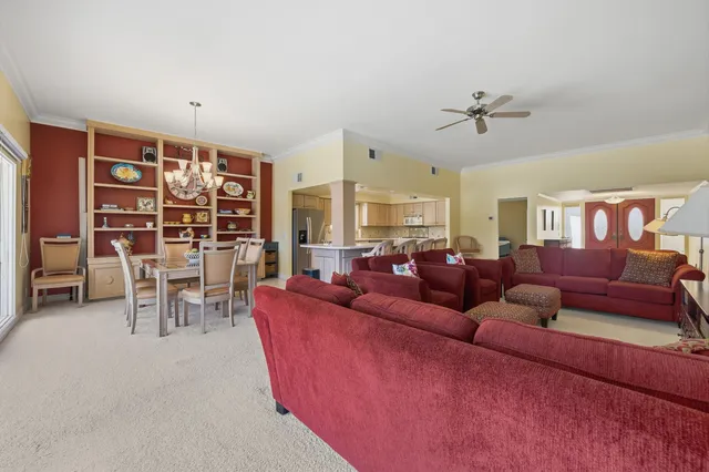 a living room with furniture kitchen view and a large window