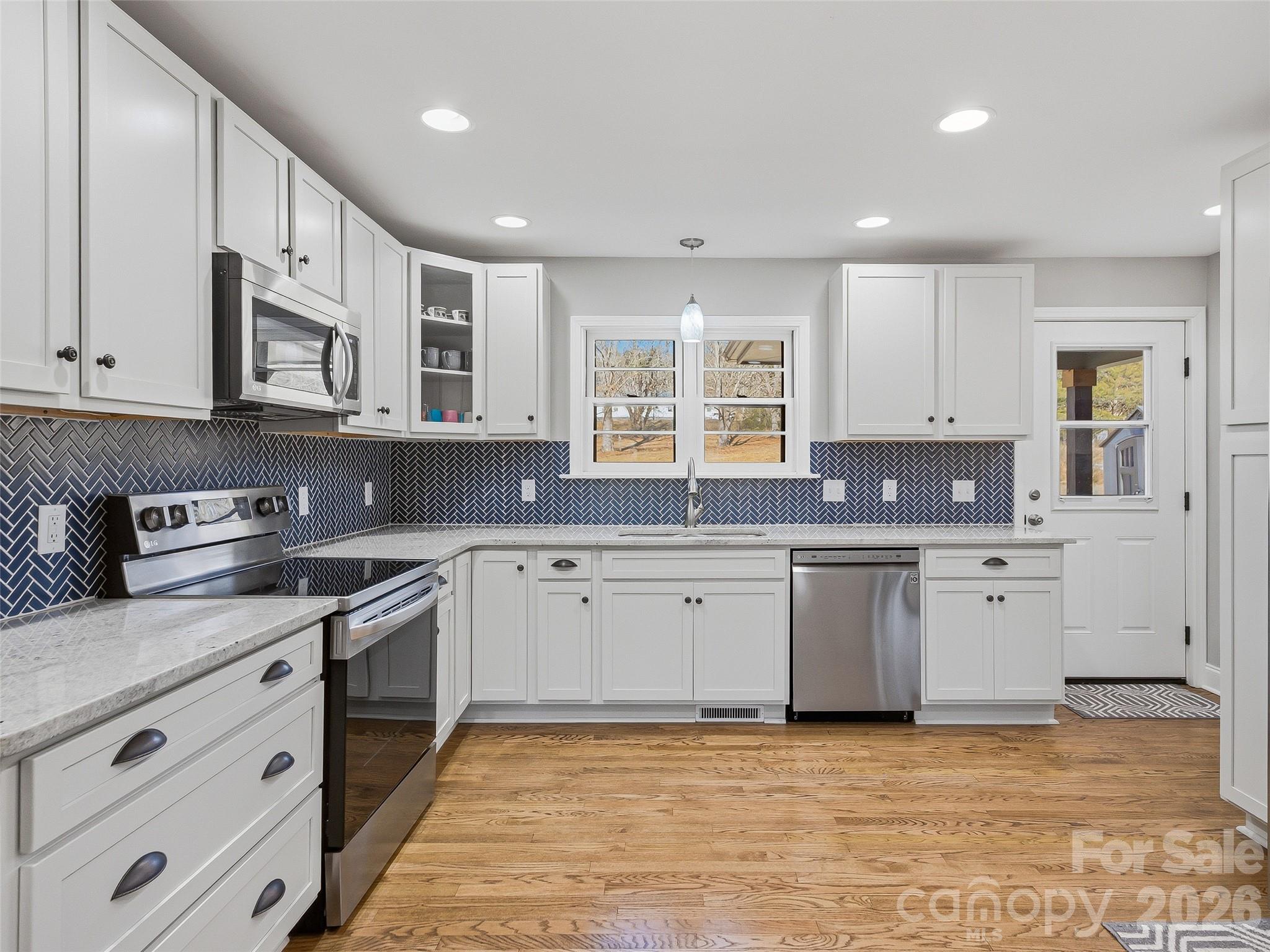 3869 Crab Creek Road Penrose, NC 28766 - Photo 7 of 19 a large kitchen with stainless steel appliances granite countertop a stove a sink dishwasher and a microwave