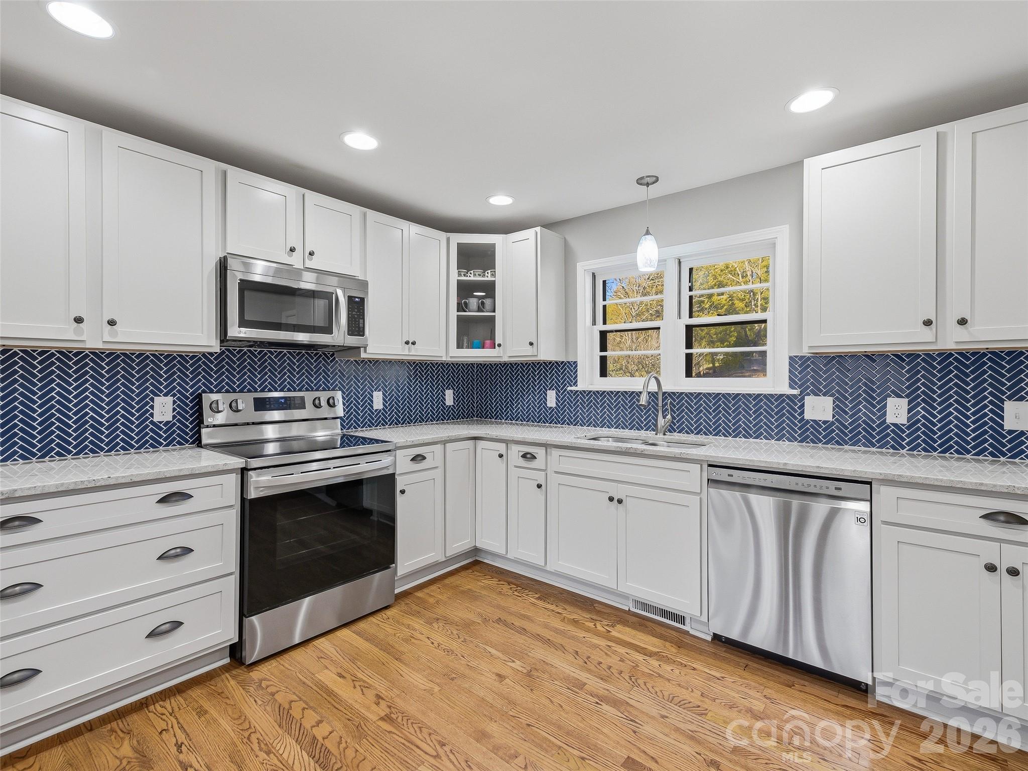 3869 Crab Creek Road Penrose, NC 28766 - Photo 8 of 19 a kitchen with granite countertop white cabinets sink and stainless steel appliances