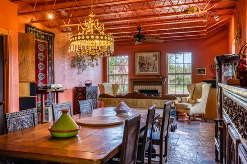 a bedroom with a bed a table and chairs with the wooden floor
