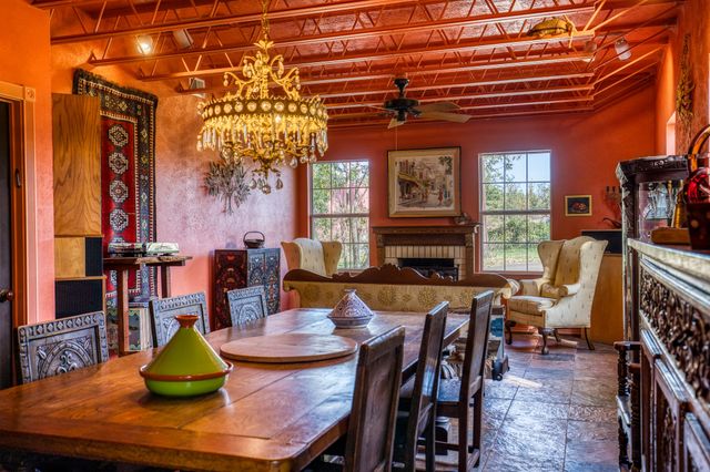 a bedroom with a bed a table and chairs with the wooden floor