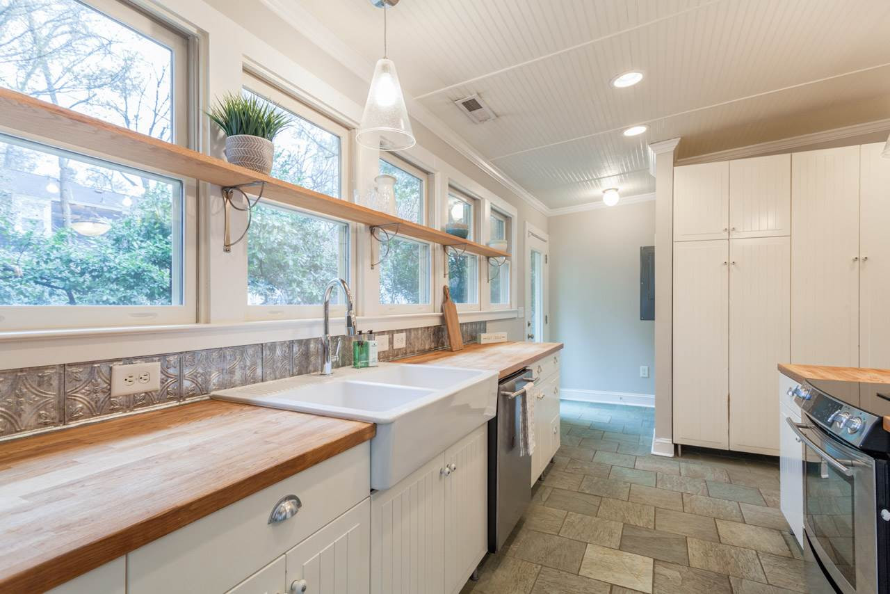 414 Frank Street Raleigh, NC 27604 - Photo 14 of 23 But if you must be inside, you might as well be in this kitchen where you can still look out. Another door to the backyard and a half bath / powder room are just beyond the wall of kitchen/pantry cabinets.