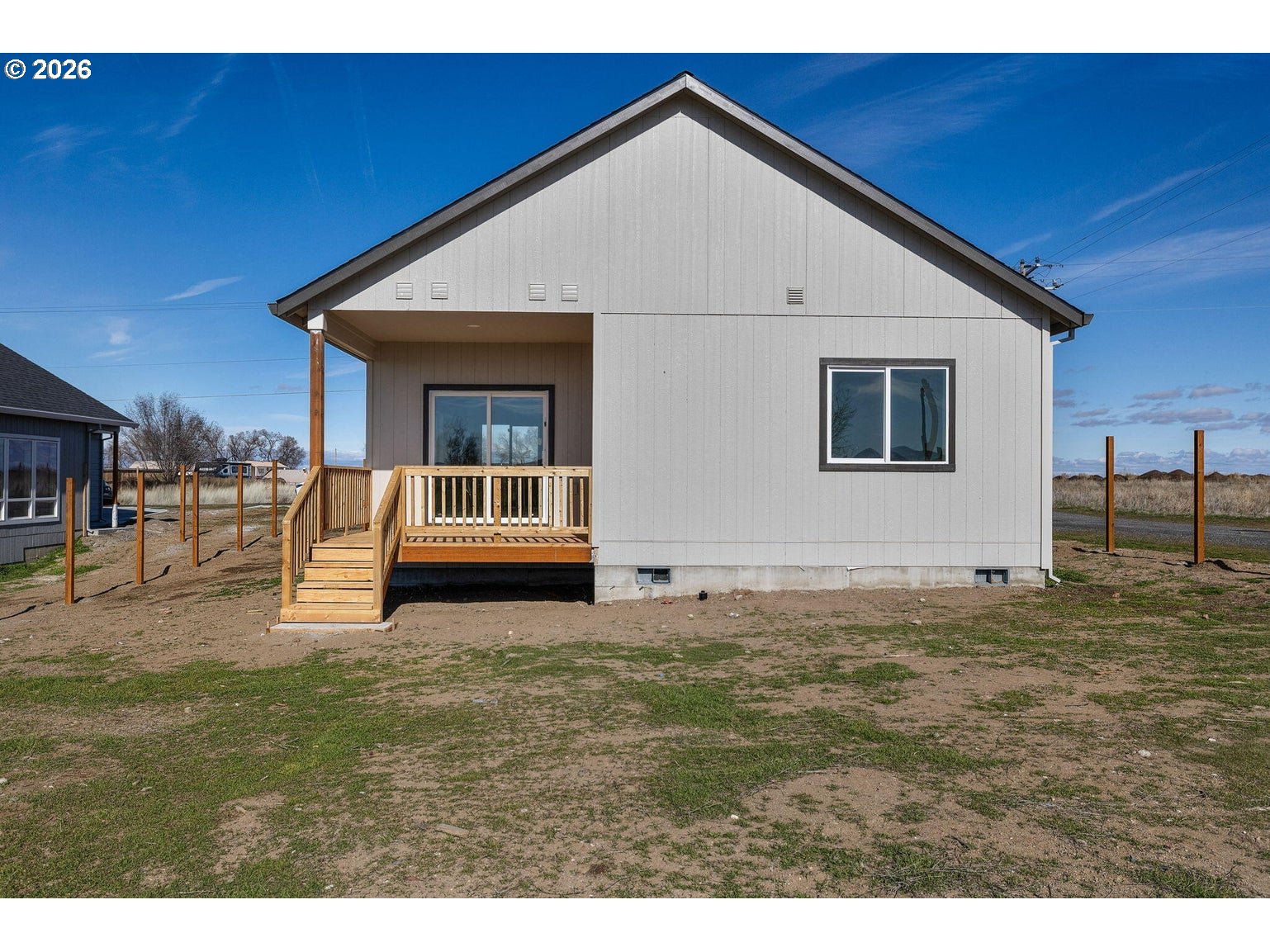 512 Southwest 6th Street Madras, OR 97741 - Photo 5 of 15 a big white house with a big yard and large trees with wooden fence