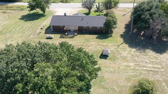 an aerial view of a house with yard and lake view