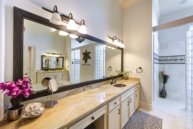 a bathroom with a granite countertop double vanity sink and a mirror