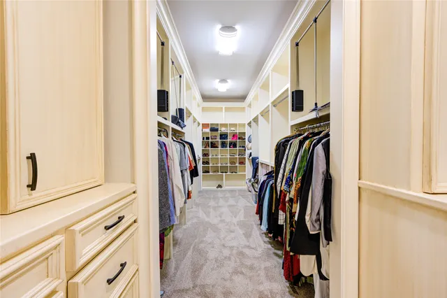 a view of walk in closet with clothes and shoes