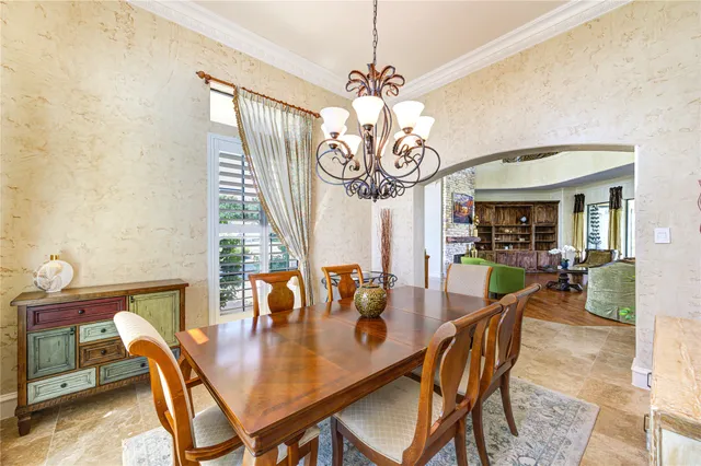 a dining room with furniture a chandelier and window