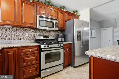 a kitchen with stainless steel appliances granite countertop a stove microwave and refrigerator