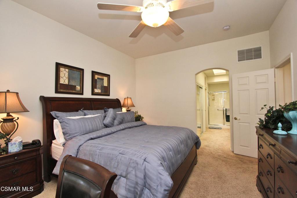 78448 Desert Willow Drive Palm Desert, CA 92211 - Photo 21 of 38 a bedroom with a bed and a chandelier