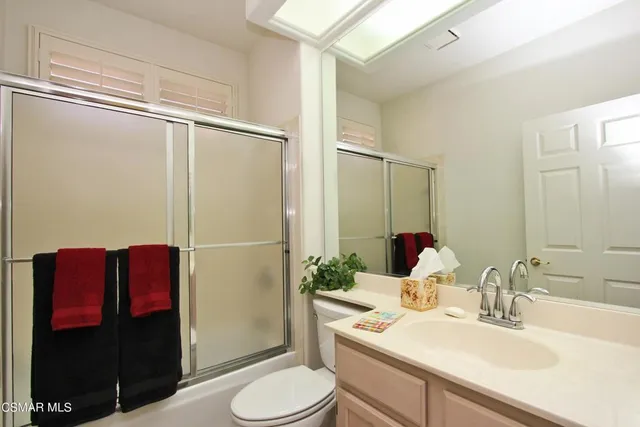 a bathroom with a sink vanity mirror and toilet