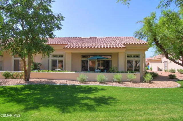 a front view of a house with a garden and yard
