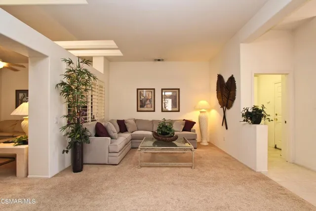 a living room with furniture and a potted plant