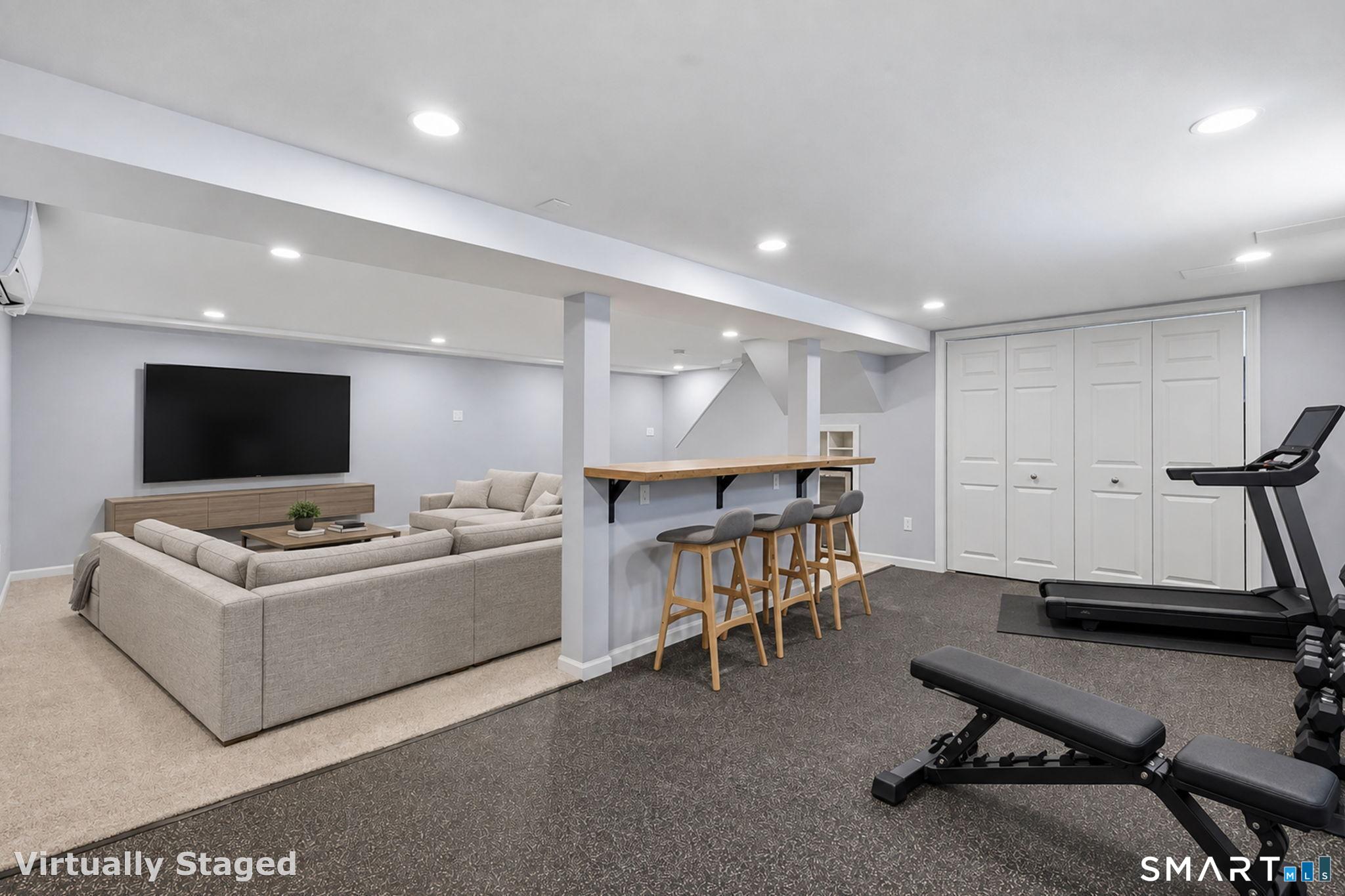6 Cornfield Road Simsbury, CT 06070 - Photo 23 of 40 The finished lower level was recently painted & the wall to wall carpet was replaced, both in September 2026. It features recessed lighting, a bar area, a beverage fridge and a gym area with rubber flooring.