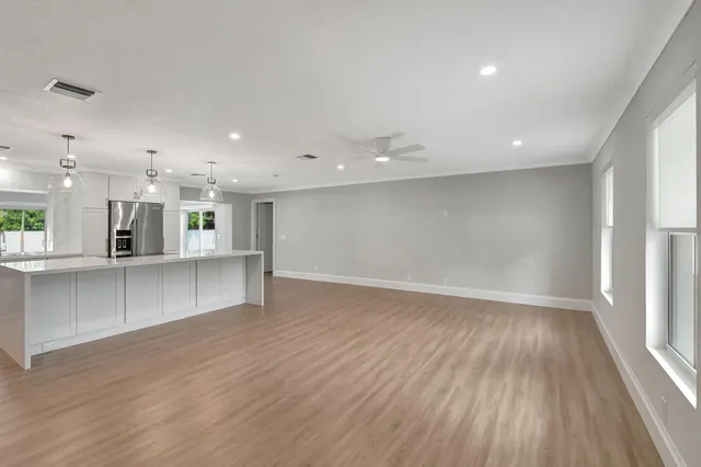 a large white kitchen with lots of counter space and stainless steel appliances
