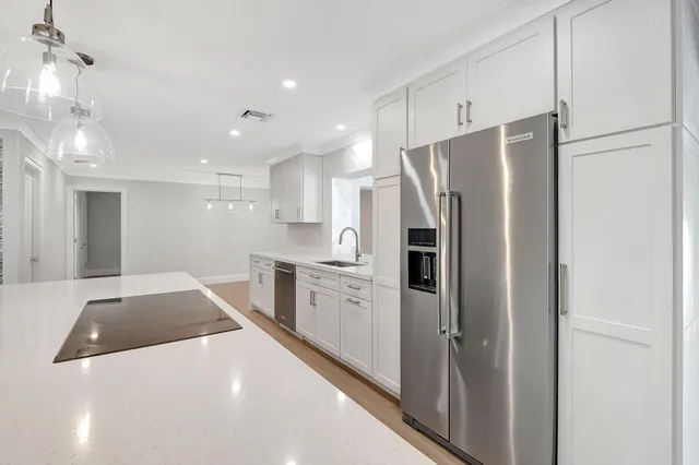 a kitchen with a sink a refrigerator and cabinets