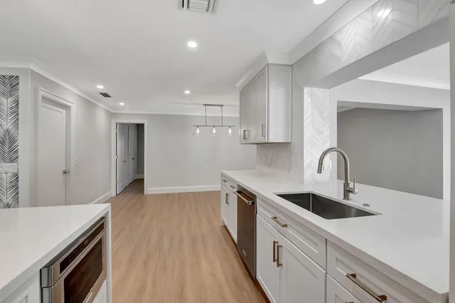 a kitchen with kitchen island a sink appliances and cabinets