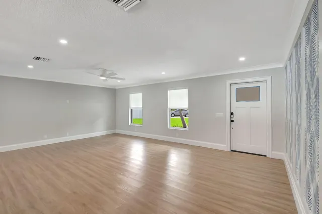 an empty room with window and wooden floor