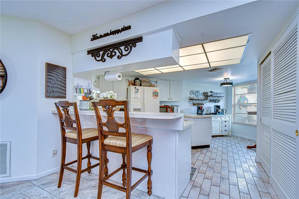 3439 Teeside Drive New Port Richey, FL 34655 - Photo 14 of 85 a kitchen with a dining table chairs cabinets and stainless steel appliances