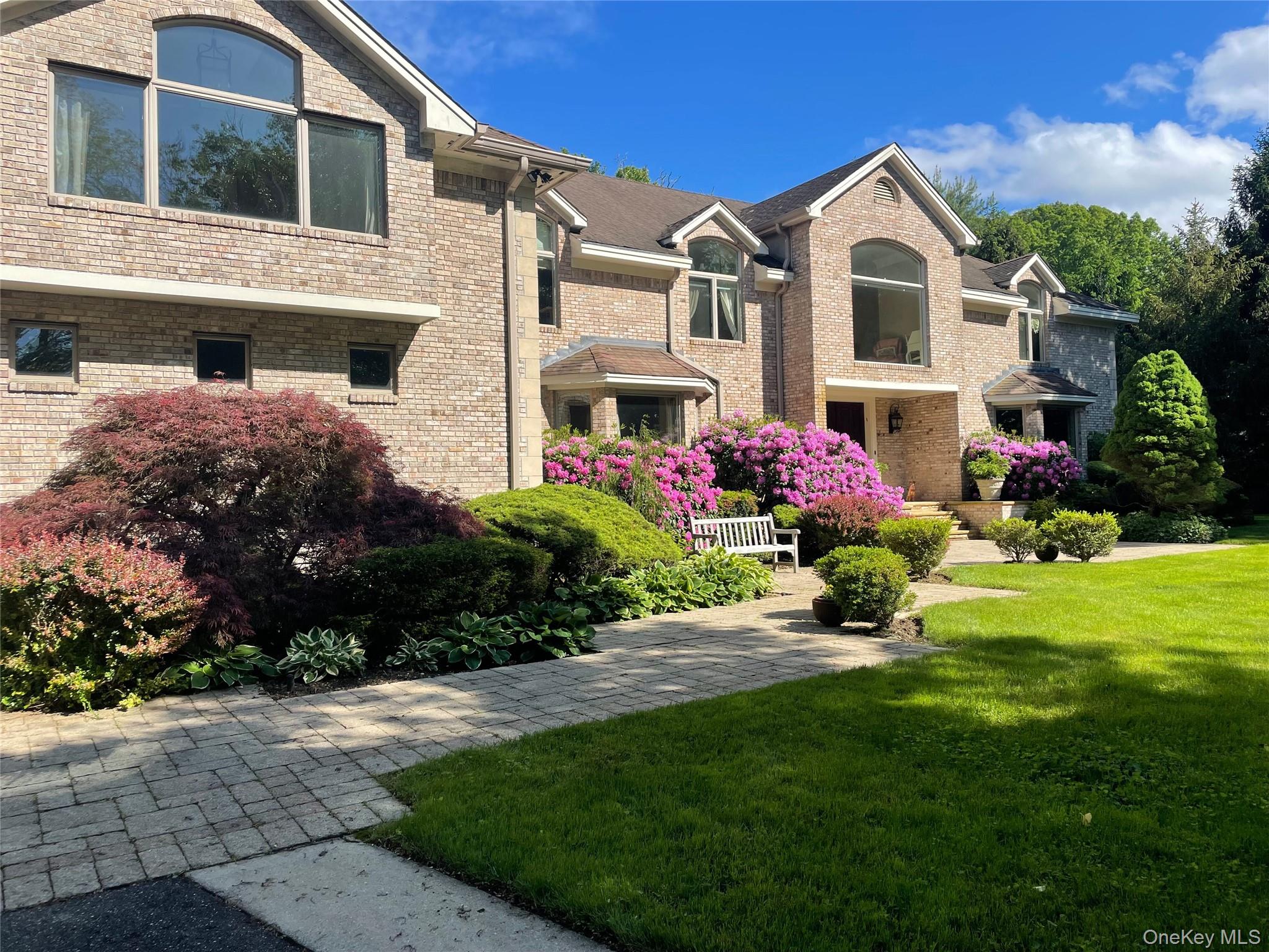 Front of colonial-style brick home, pavered driveway