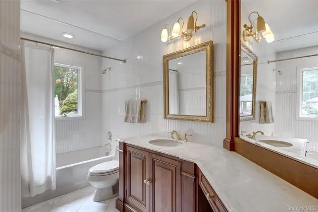 a bathroom with a sink vanity granite toilet and a mirror