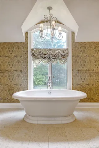 a white bath tub sitting in a bathroom next to a window