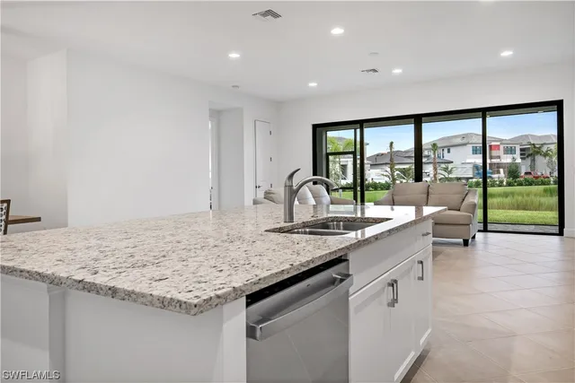 a kitchen with sink and view of living room
