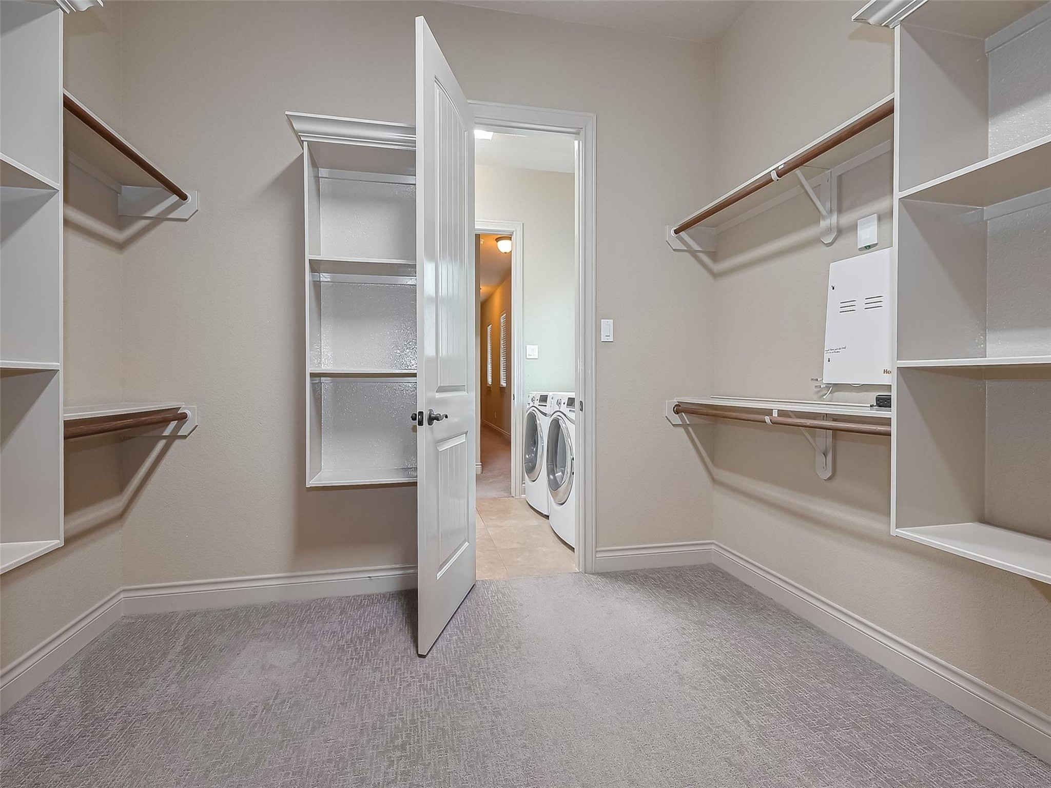 2711 King Point View Lane Spring, TX 77388 - Photo 21 of 48 Enjoy the large walk-in closet with ample shelving and hanging space. The room opens to a laundry area with modern appliances, providing convenient access.