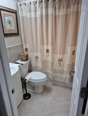 a bathroom with a toilet and a shower curtain