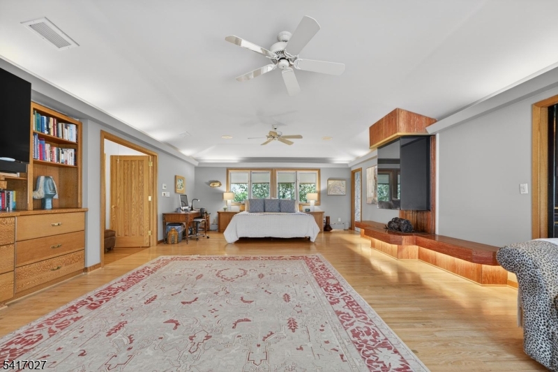 166 River Road Annandale, NJ 08801 - Photo 24 of 37 a bedroom with a large bed and a chandelier fan