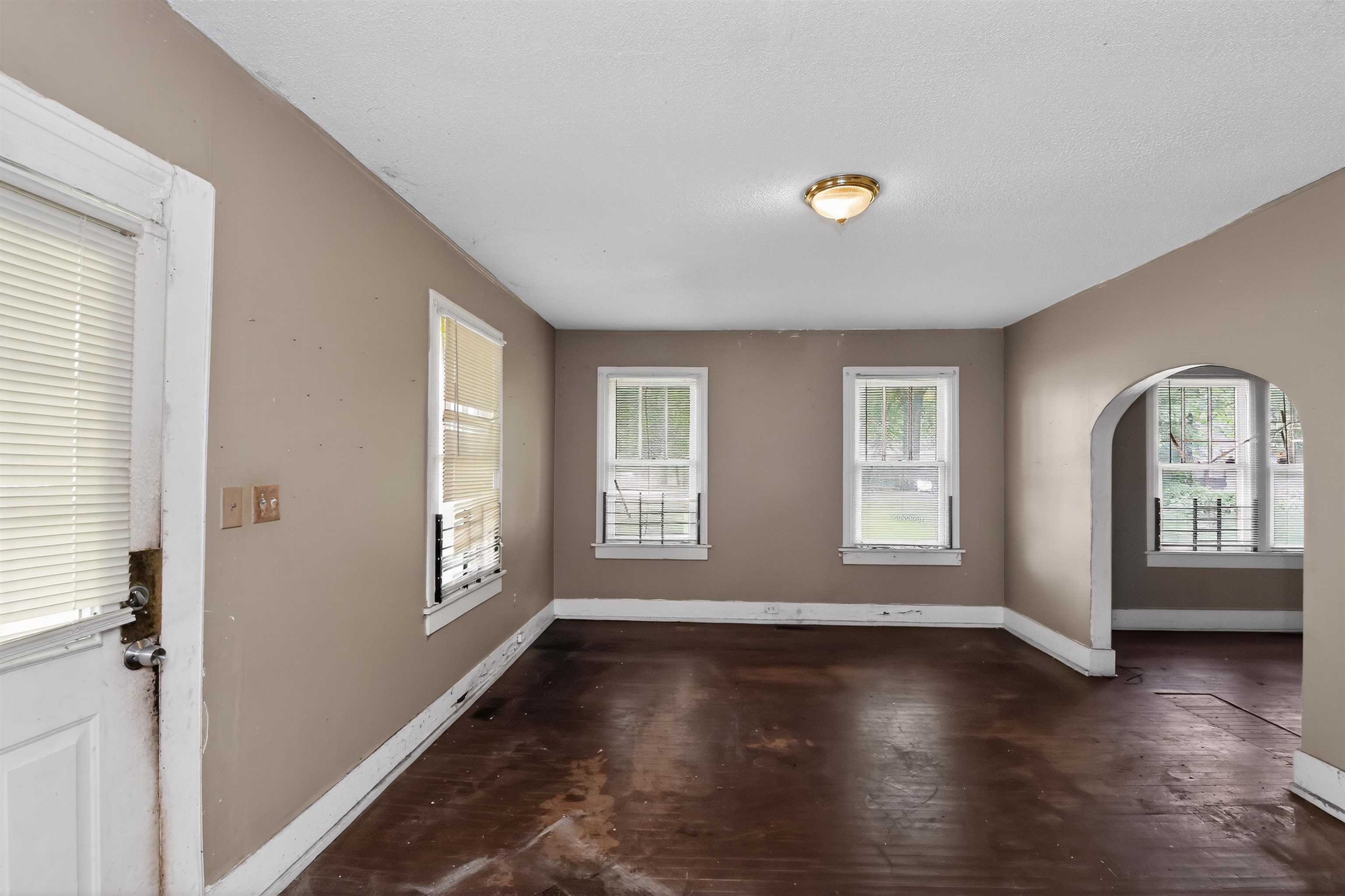810 Hale Road Memphis, TN 38116 - Photo 8 of 30 Interior room featuring wood-finish flooring, two windows with white trim, and a brass-finish ceiling light fixture
