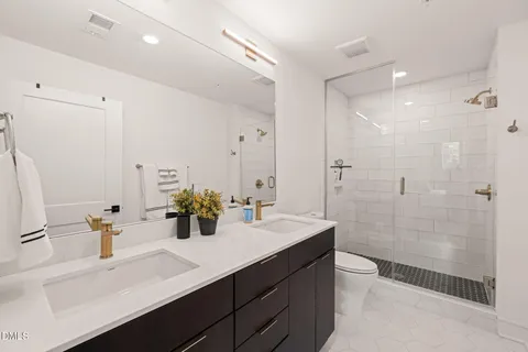 a bathroom with a sink a toilet and shower