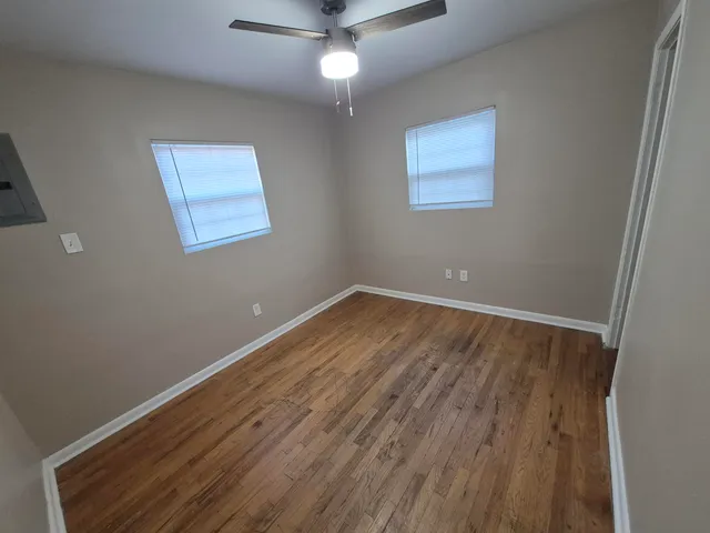 a view of room with wooden floor and ceiling fan