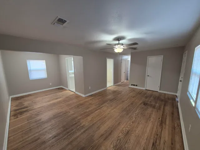 a view of an empty room with a chandelier fan