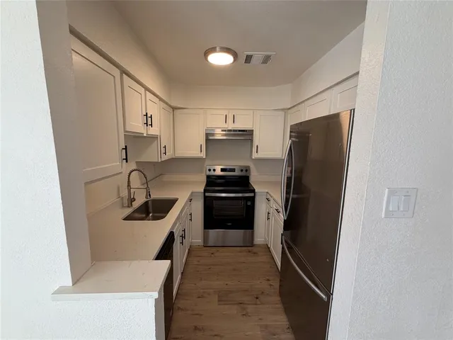 a kitchen with a refrigerator and a sink