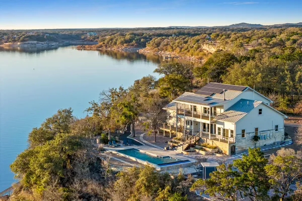 an aerial view of residential houses with outdoor space and lake view