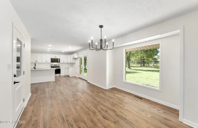 a view of a kitchen with microwave and refrigerator