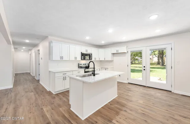 a view of kitchen with sink and refrigerator