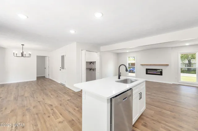 a living room with a sink and a refrigerator