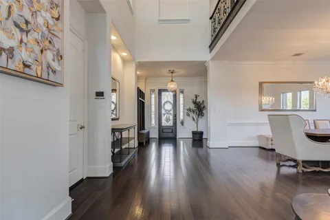 a view of a hallway with wooden floor and a living room