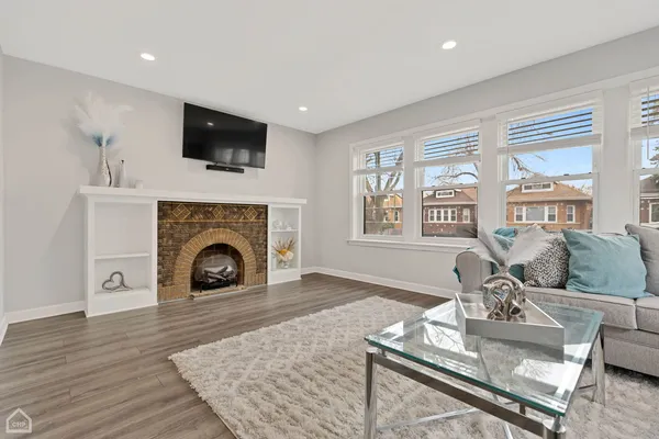 a living room with furniture a flat screen tv and a fireplace