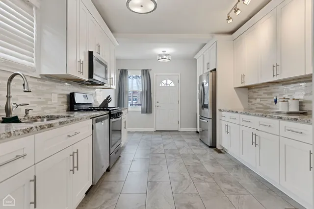 a kitchen with granite countertop a sink and cabinets