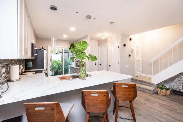a view of a dining room and livingroom with furniture wooden floor and a chandelier