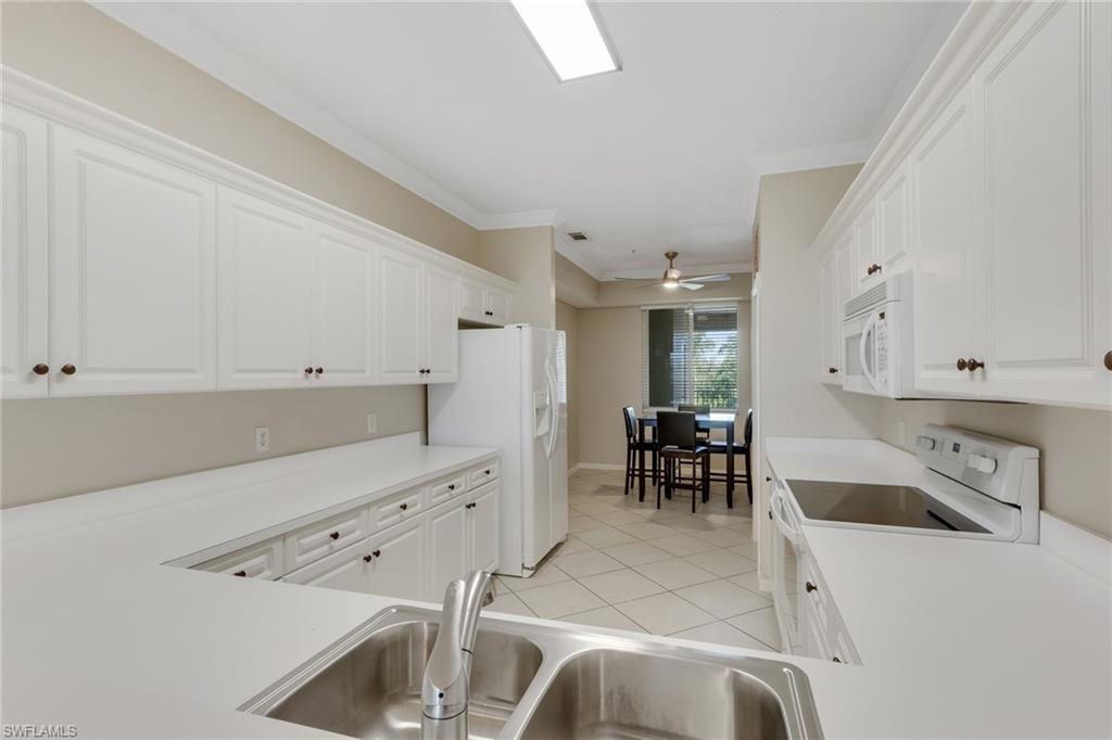 8570 Kingbird Loop, Unit 542 Estero, FL 33967 - Photo 12 of 43 a kitchen with a sink a stove and chairs