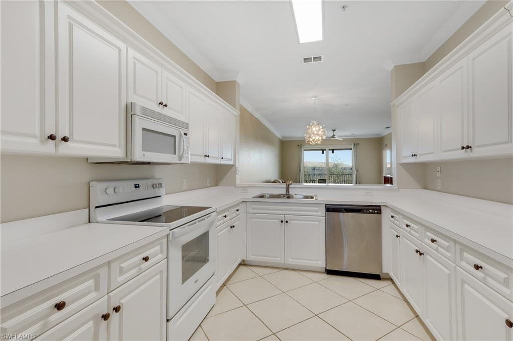 8570 Kingbird Loop, Unit 542 Estero, FL 33967 - Photo 13 of 43 a kitchen with white cabinets appliances and a window